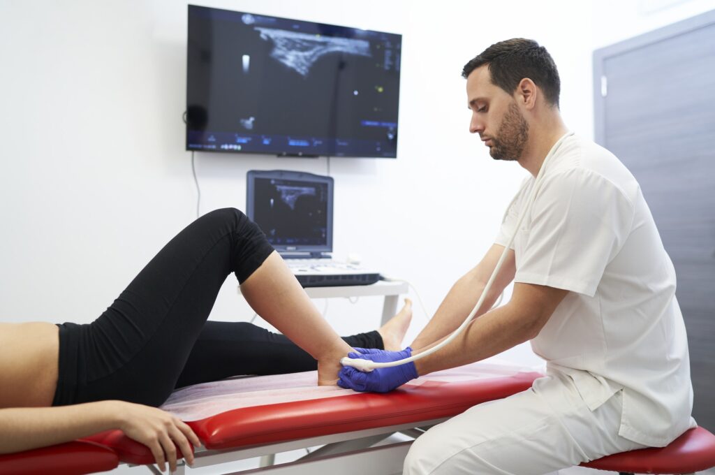 a physiotherapist performing an ultrasound on the ankle to check for injury