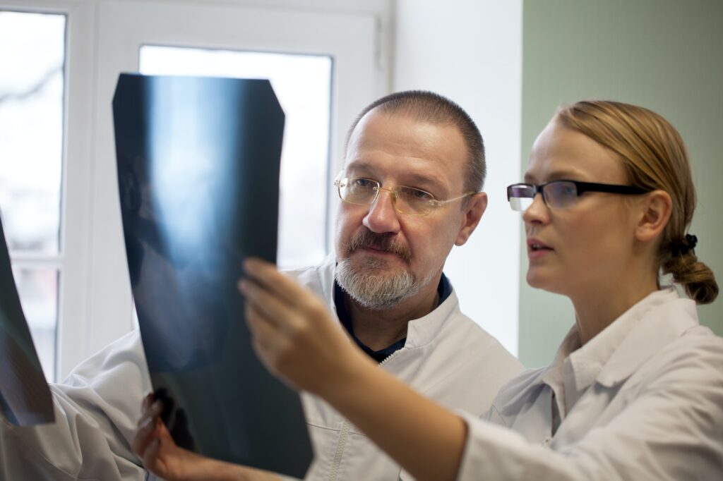 Senior and young doctors examining x-ray images