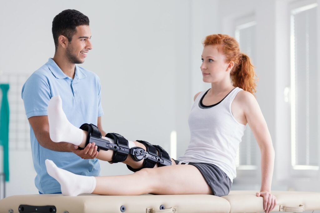 Young woman wearing a brace during rehabilitation with her physi